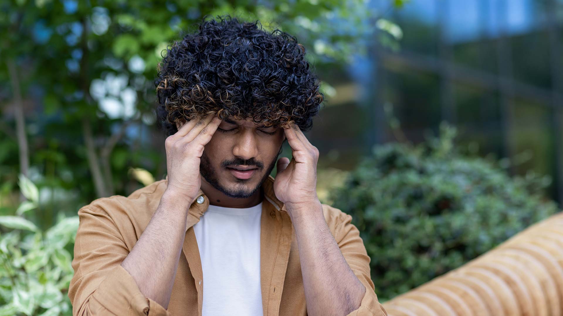 man suffering a migraine in public