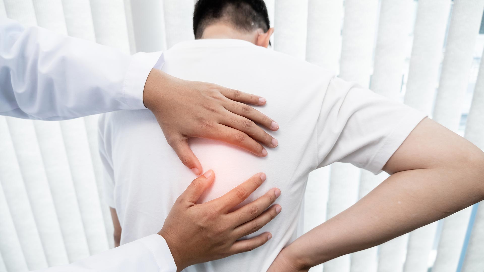 male patient at the chiropractor for a pinched nerve in back